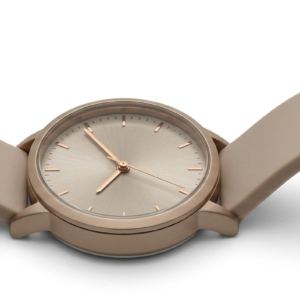 Reloj de dama con correa de silicona beige, carátula redonda y detalles en dorado rosado.