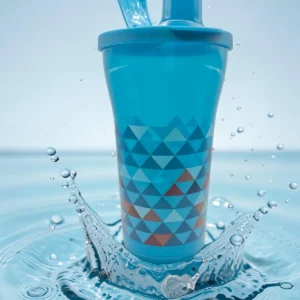 Vaso azul con tapa y pitillo integrado, estampado de triángulos, sobre splash de agua