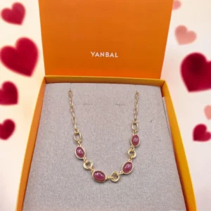Collar Yanbal dorado con dijes ovalados rosados, presentado en su caja original.