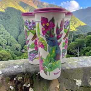 Tres vasos Tupperware blancos con estampado de colibrí y flores, tapa vino tinto, sobre muro de piedra.